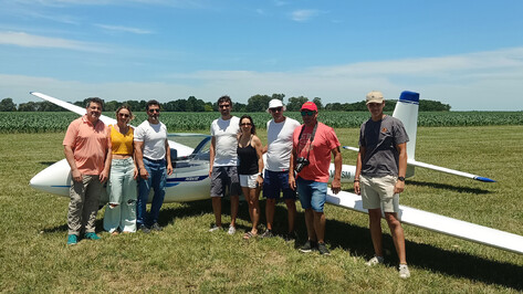 Gruppenfoto von Personen neben einem SZD-54-2 Perkoz auf einer Wiese.